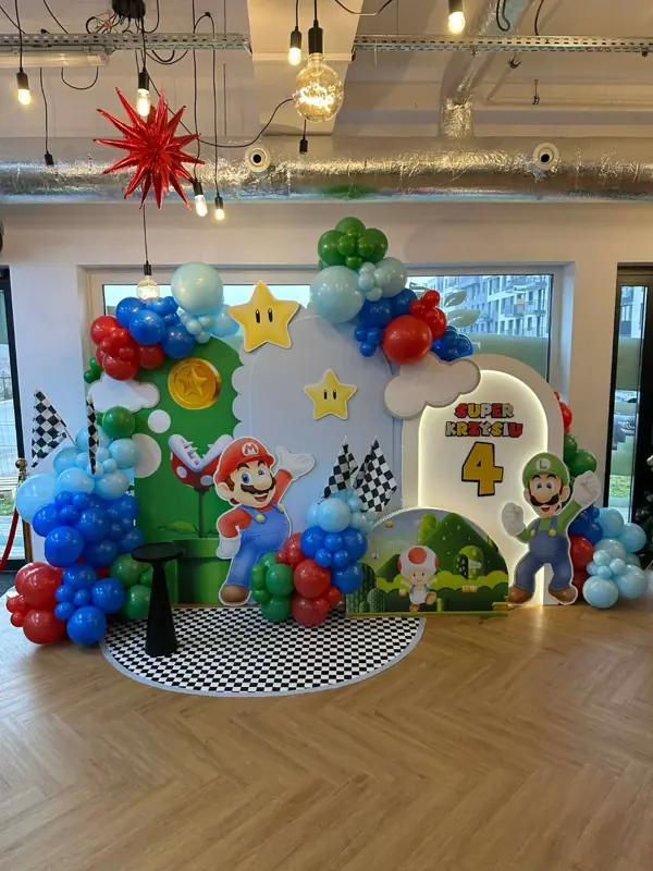 Ścianka urodzinowa w motywie Mario z balonami i podświetlanym napisem z imieniem i wiekiem dziecka