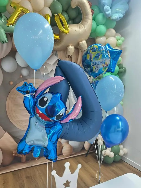 Balony z helem: cyfra 4 i balon ze Stitchem przy dekoracji z dinozaurami